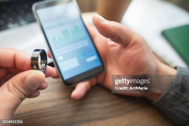 man with smart ring and smartphone indoors - wearable computer stock pictures, royalty-free photos & images