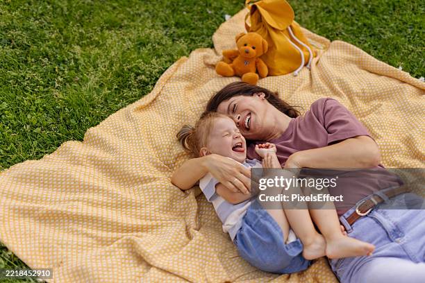 loving cuddle between mother and child - family picnic stock pictures, royalty-free photos & images