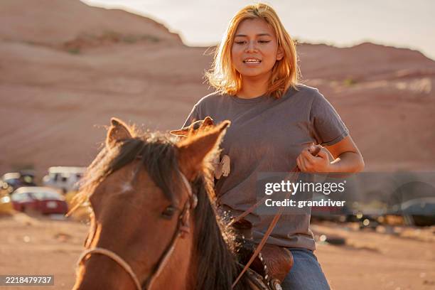 pretty navajo girl riding horseand holding a chihuahua dog in the desert near monument valley arizona in the american southwest - native american reservation stock pictures, royalty-free photos & images