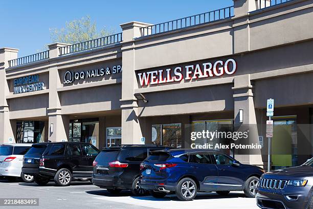 shopping plaza with wells fargo branch. cars parked in front of retail businesses on sunny day. - strip mall stock pictures, royalty-free photos & images