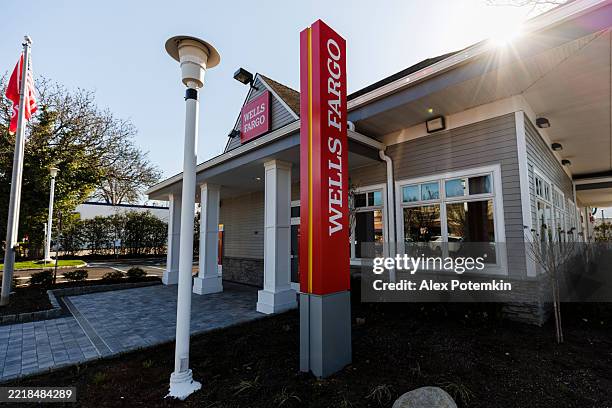 banking location in port washington, ny. exterior view of wells fargo branch with vertical sign and streetlamp. - fargo skyline stock pictures, royalty-free photos & images