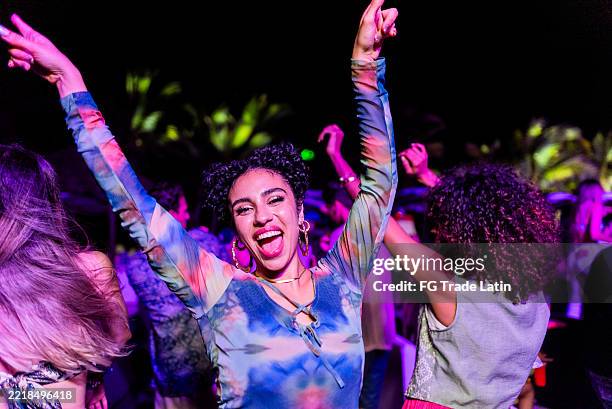 giovane donna che balla durante la festa all'aperto - locale notturno foto e immagini stock