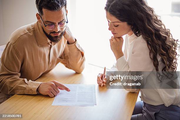 colleagues reading and discussing a document at the office - woman reading script stock pictures, royalty-free photos & images