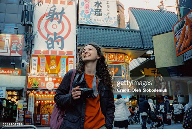 woman photographing with camera in osaka during trip to japan - toerist stockfoto's en -beelden