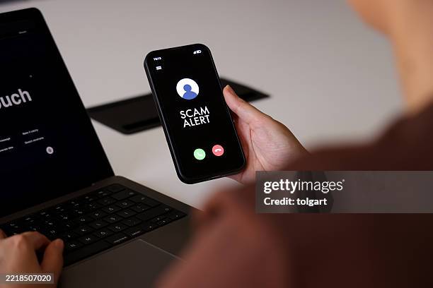 betrugswarnung auf dem smartphone-bildschirm während eines eingehenden anrufs - scammer trickbetrüger stock-fotos und bilder