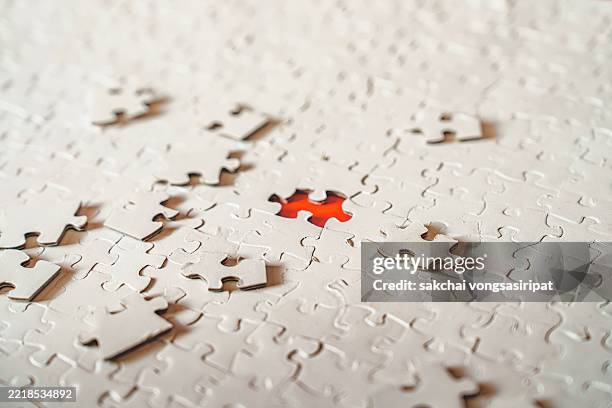 a final jigsaw puzzle piece into a last blank, 1q test, successful problem solving concept - unvollständig stock-fotos und bilder
