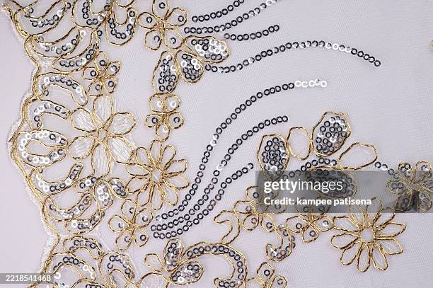a piece of lace with a glittery design on it. the lace is white and has a shiny, sparkly appearance - lace textile stock pictures, royalty-free photos & images