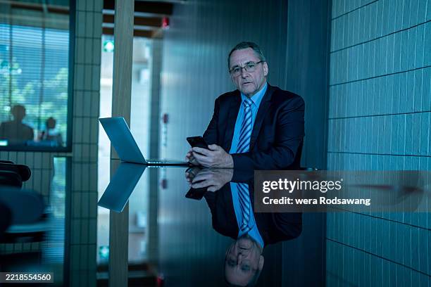 the senior chief executive exudes confidence as they tackle important tasks at their desk - bring your own device stock-fotos und bilder
