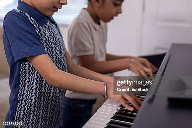 boys learning keyboard together - bangle stock pictures, royalty-free photos & images