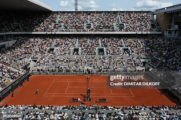 Spectators watch the men's singles final match between Spain's Carlos Alcaraz and Italy's Jannik Sinner on day 15 of the French Open tennis...