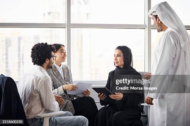 multiethnische wirtschaftsexperten, die ideen miteinander austauschen - vereinigte arabische emirate stock-fotos und bilder