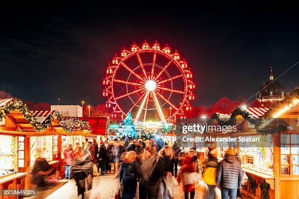 illuminated spinning ferris wheel at christmas market in berlin, germany - berlin winter stock pictures, royalty-free photos & images