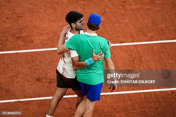 Spain's Carlos Alcaraz embraces Italy's Jannik Sinner after winning the men's singles final match on day 15 of the French Open tennis tournament on...