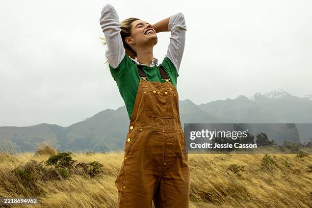 a woman stands in a dramatic landscape - una mujer de mediana edad solamente fotografías e imágenes de stock