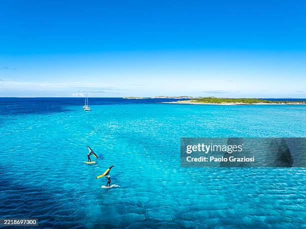 deux personnes s’adonnant au wing foil dans le bleu cristallin de la mer, corse - corse photos et images de collection