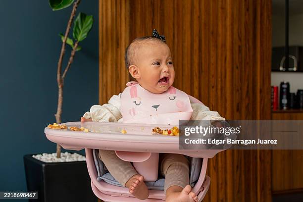 baby girl crying while eating in high chair - tears of joy stock pictures, royalty-free photos & images