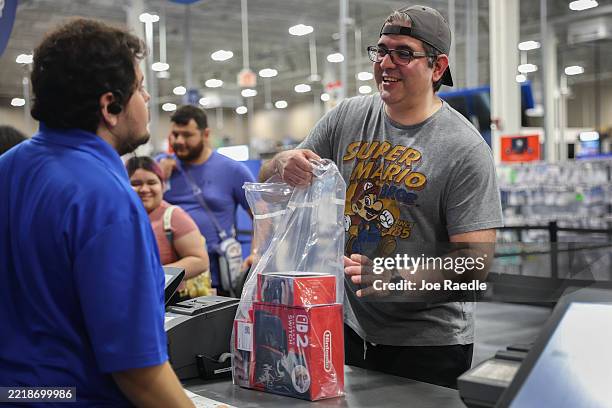 Darrell Zimmer purchases a Nintendo's Switch 2 console at a midnight opening of a Best Buy store on June 05, 2025 in Pembroke Pines, Florida. The...