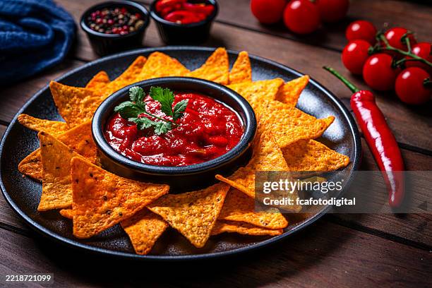 nacho chips and salsa shot on rustic wooden table - salsa imagens e fotografias de stock