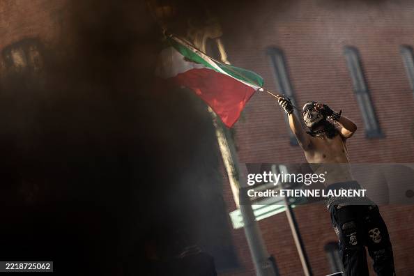 Waymo Flag A demonstrator waves a Mexican flag next to burning Waymo cars as ...