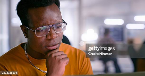 focused young professional analyzing data on screen in modern office environment - rethinking stock pictures, royalty-free photos & images