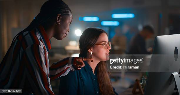 collaboration between two professionals in a modern office setting - low lighting stock pictures, royalty-free photos & images