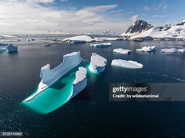 aerial view of a very large iceberg and antarctic landscape. - antarctica stock pictures, royalty-free photos & images
