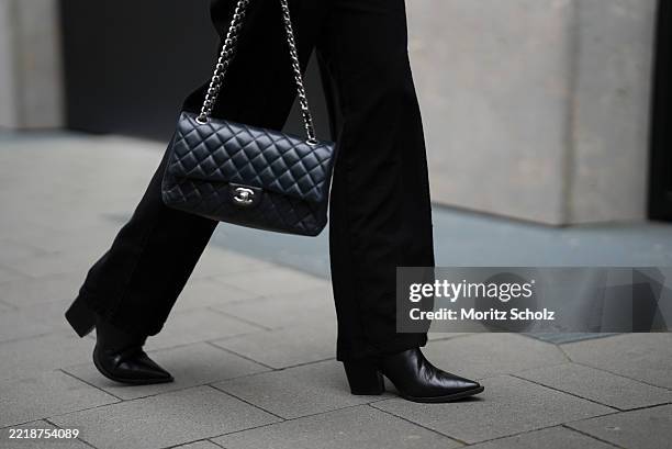Mrs Bella is seen wearing black leather ankle boots in tapered shape with block heel from Thea Mika, high waisted black wide-leg-jeans from Massimo...