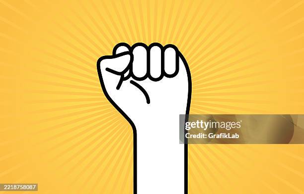 raised fist illustration on yellow radiant background symbolizing strength and unity - raised fist stock illustrations
