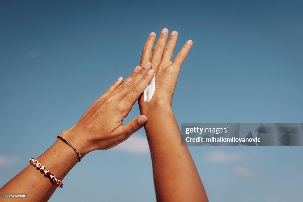 Applying Sun Cream Under Clear Blue Sky