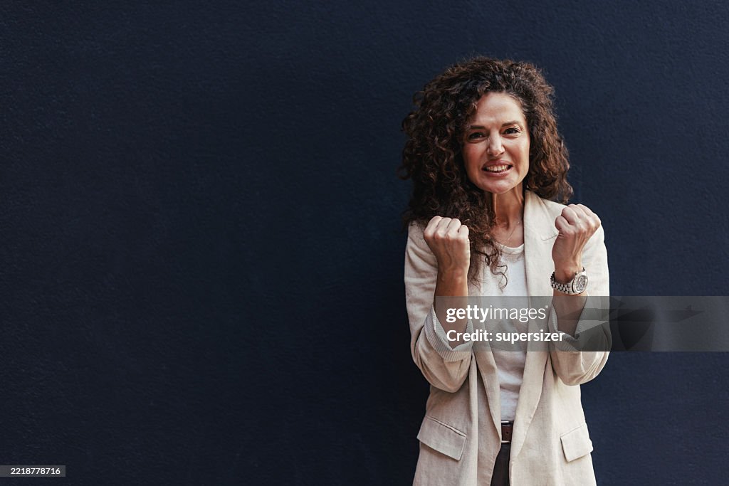 Aufgeregte Frau feiert mit erhobenen Fäusten