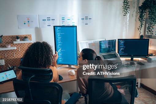 Diversity Female software developers collaborating on code review at tech workstation Diversity Female software developers collaborating on code review at tech workstation