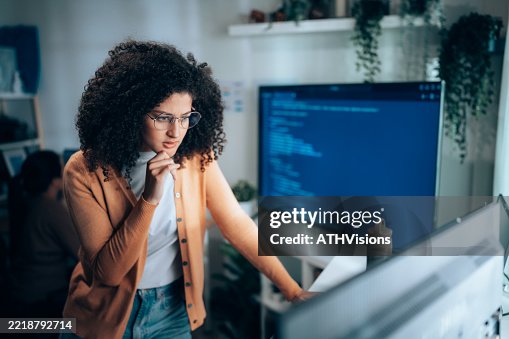 Woman software engineer analyzing program code at laptop workstation Woman software engineer analyzing program code at laptop workstation