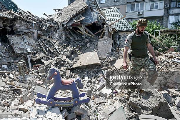 Serviceman passes a rocking horse on the ruins of a house destroyed by a Russian guided aerial bomb strike in Zaporizhzhia, Ukraine, on June 9, 2025....