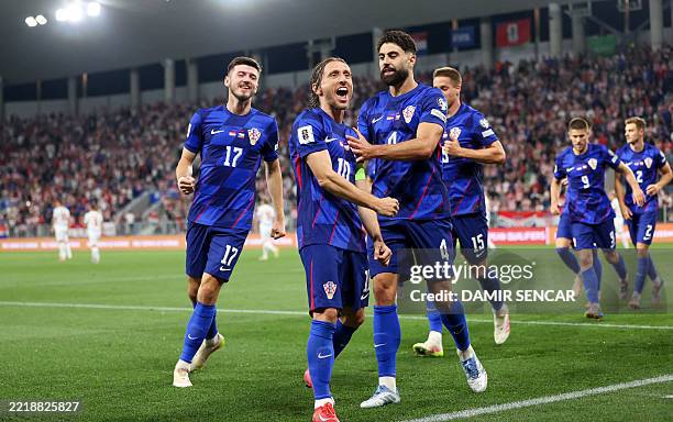 Croatia's midfielder Luka Modric celebrates, with Croatia's defender Josko Gvardiol and Croatia's midfielder Petar Sucic , after scoring his team's...