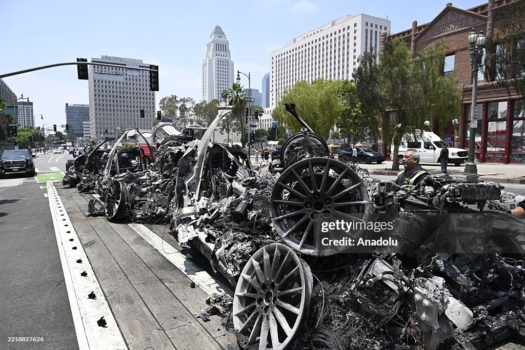 Cybercab Waymo Riot Workers clean up debris after violently burned five autonomous Waymo ...