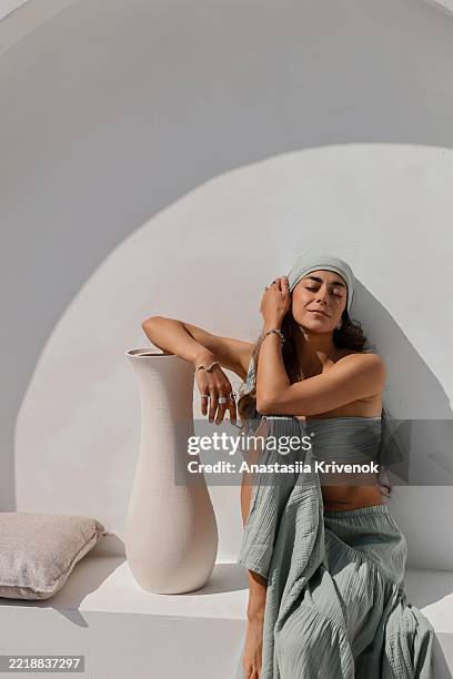 woman relaxing in sunlit minimalist setting with stylish boho outfit - comfort zone stock pictures, royalty-free photos & images