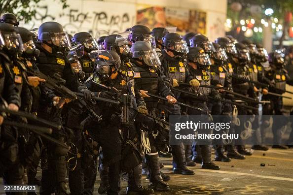 Smiling Riot Police Police officers in riot stand during a demonstration following... News ...
