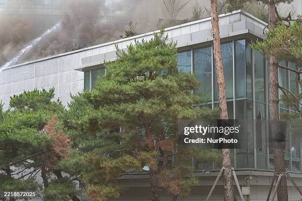 Firefighters work to extinguish a blaze at the international conference hall of the Korean Buddhist History and Culture Memorial Center next to...
