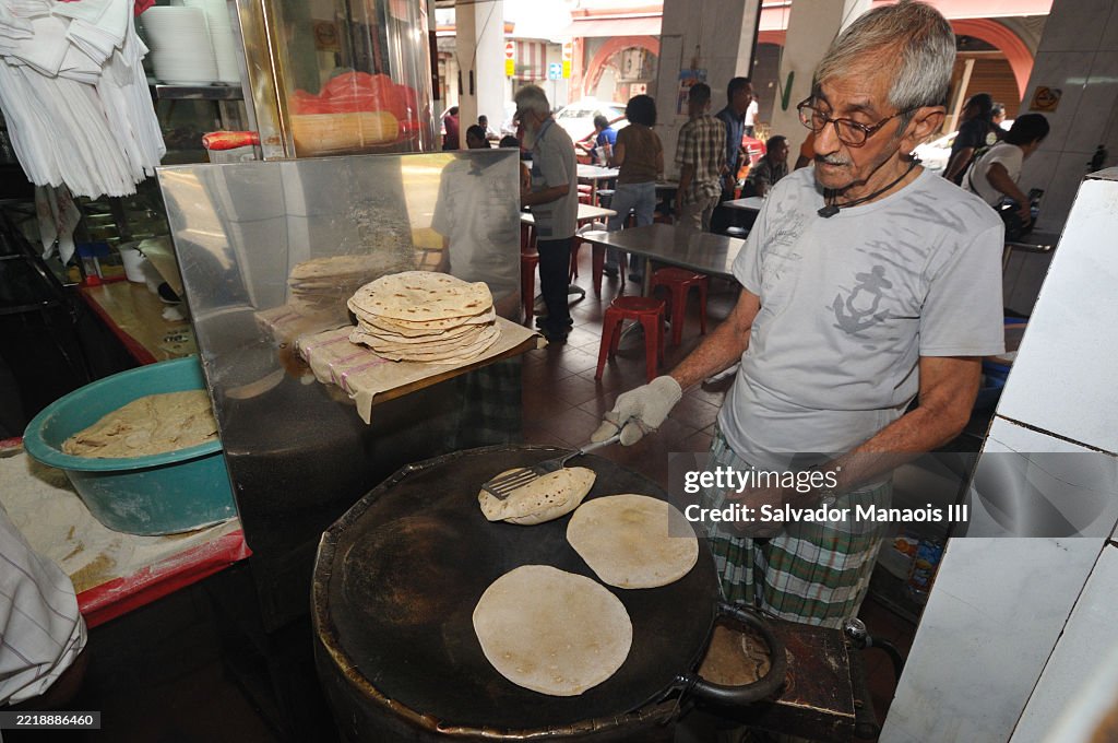 An elderly man preparing chapati