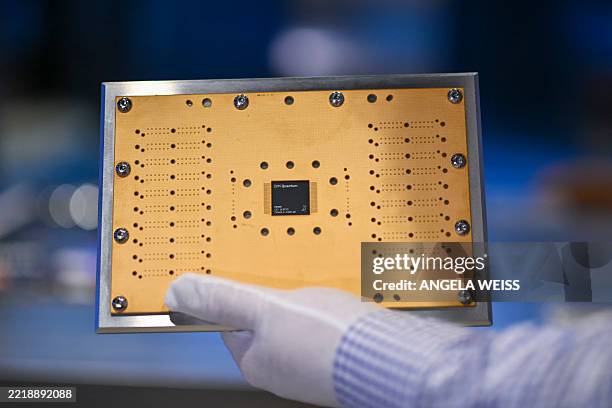 Person holds up a printed circuit board with a quantum processing unit at the IBM Thomas J. Watson Research Center on June 6, 2025 in Yorktown...