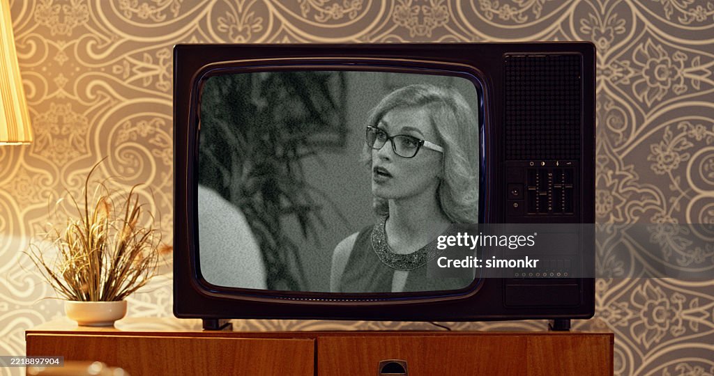 Retro CRT Television Displaying Black And White Movie Scene In Vintage Room Setting