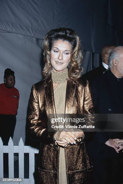 Canadian singer Celine Dion, wearing a gold jacket over a gold halterneck dress, attends the 7th Annual Billboard Music Awards at the Hard Rock Hotel...