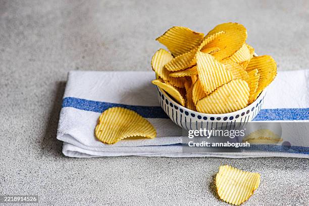 close-up of a bowl with homemade potato crisps on a folded tea towel - potato chip stock pictures, royalty-free photos & images