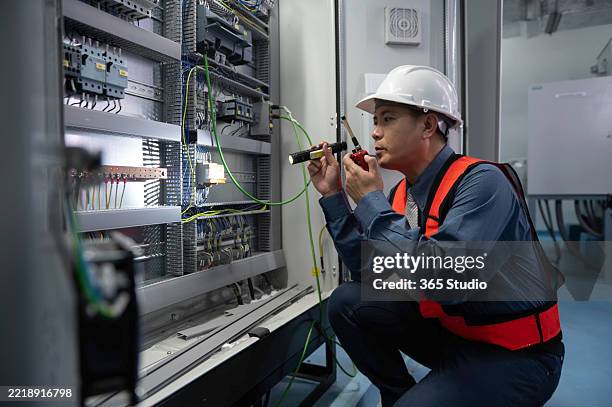 le persone lavorano sul quadro elettrico di controllo - elettricista foto e immagini stock