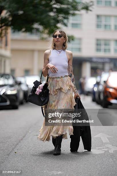 Emy Venturini wears a white ribbed sleeveless top from Zara paired with a high-waisted, multi-layered skirt from Zara featuring a pastel floral...
