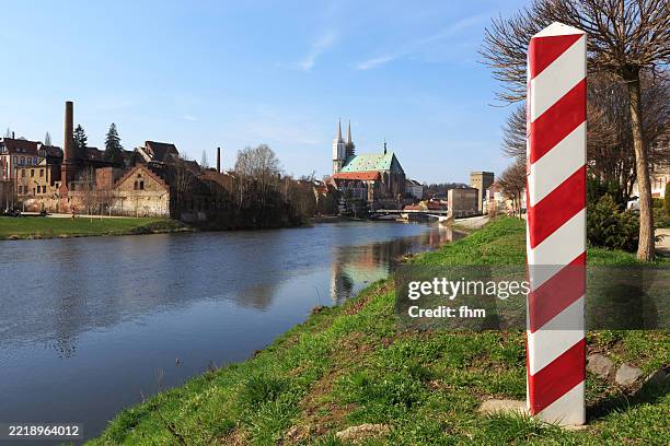 polish boundary post with polish national colors in zgorzelec with view to german district görlitz old town with landmark cathedral "st. peter and paul" - frontera internacional fotografías e imágenes de stock