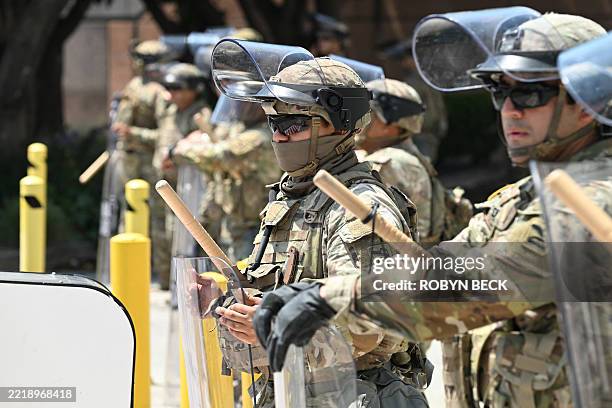 Members of the California National Guard form a line near the entrance to a federal building's loading dock and parking garage, where a small group...