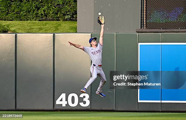 Evan Carter of the Texas Rangers leaps to catch a fly ball for an out against the Minnesota Twins in the third inning of the game at Target Field on...