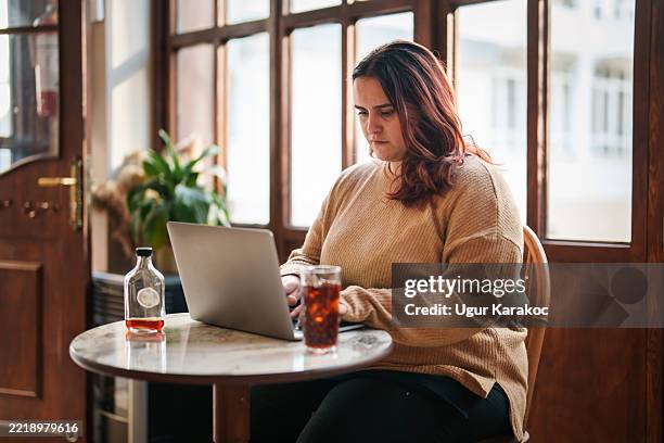 junge frau mit positiven emotionen, die an laptop im café arbeitet - osteuropäischer abstammung stock-fotos und bilder
