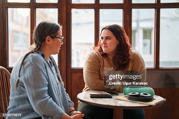 woman meeting her female friend at coffee shop - hot drink stock pictures, royalty-free photos & images